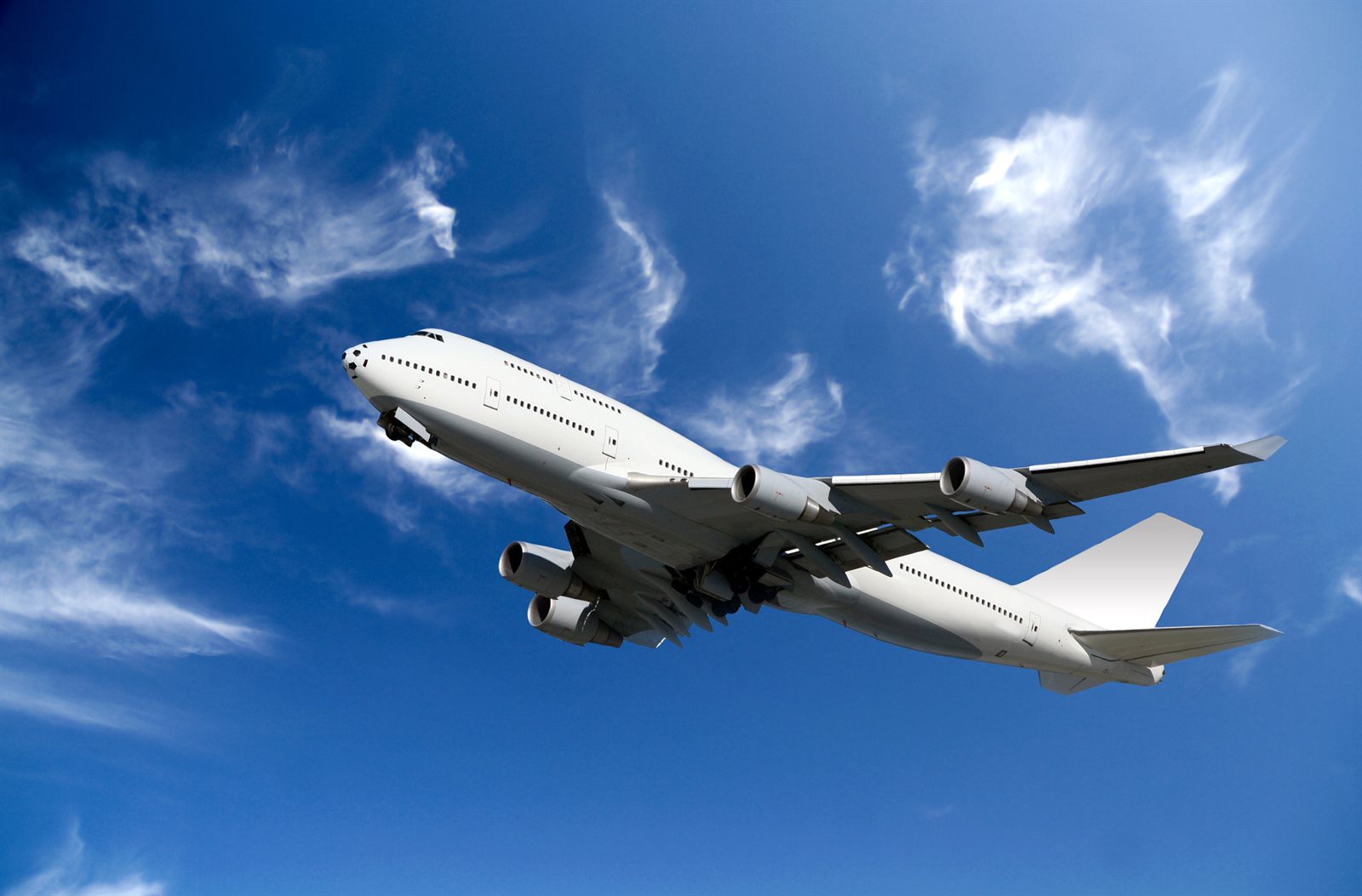 Passenger jet climbing against a blue sky