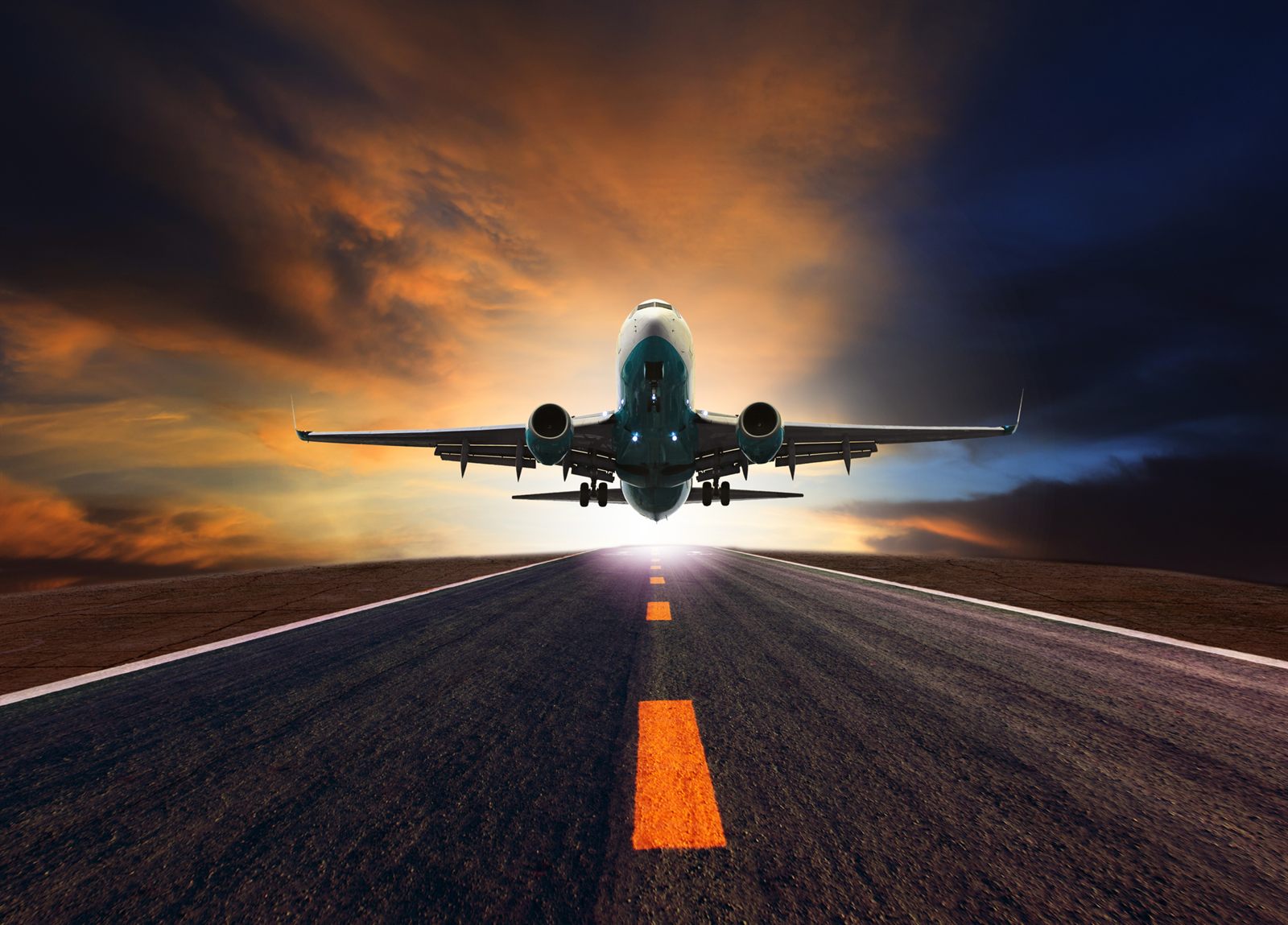 Jet lifting off a runway at sunset
